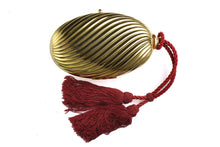 Golden oval-shaped clutch with tassel