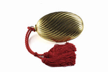 Golden oval-shaped clutch with tassel