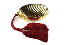Golden oval-shaped clutch with tassel