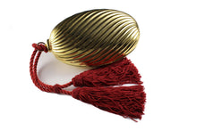 Golden oval-shaped clutch with tassel