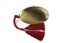 Golden oval-shaped clutch with tassel
