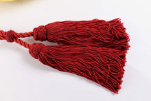 Golden oval-shaped clutch with tassel