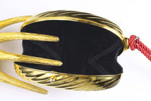 Golden oval-shaped clutch with tassel
