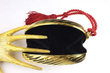 Golden oval-shaped clutch with tassel