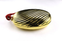 Golden oval-shaped clutch with tassel