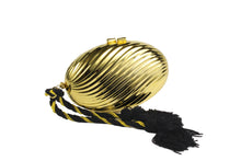 Golden oval-shaped clutch with tassel